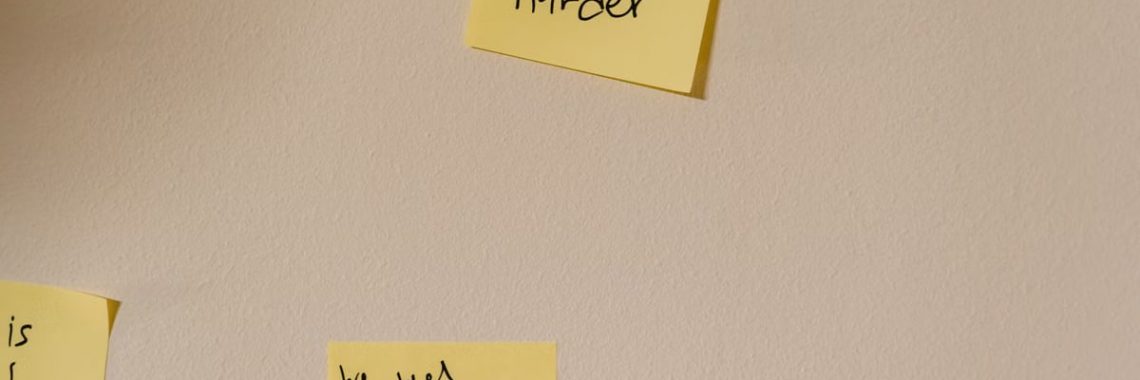 Yellow sticky notes with motivational phrases posted on a white wall, inspiring action.